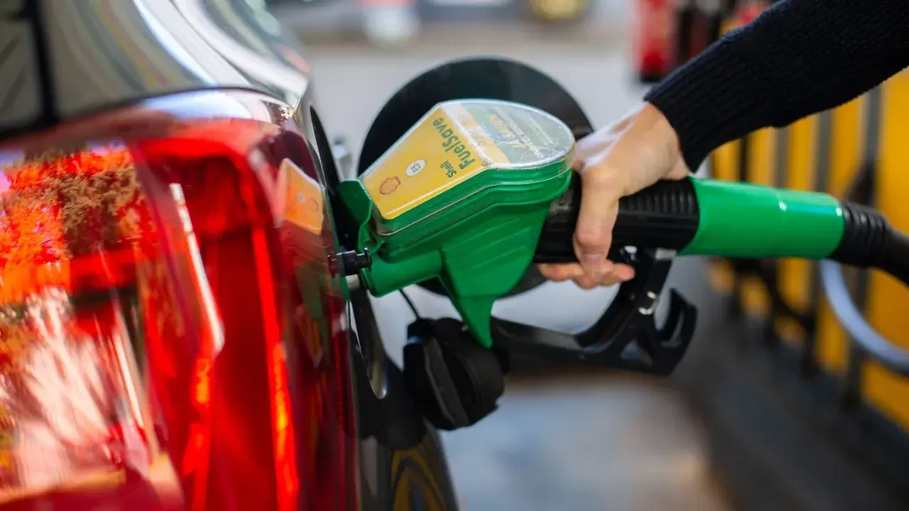 Tankstelle: Eine Hand betankt ein Auto mit dem grünen Zapfhahn. So behältst du im Blick, wie viel verbraucht dein Auto.