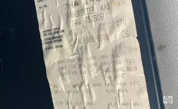 Aufkleber mit Fahrzeugdaten, um die PR-Nummern zu entschlüsseln. Zeigt Transporter, Motorcode AXB, Lacknummer und Optionen.