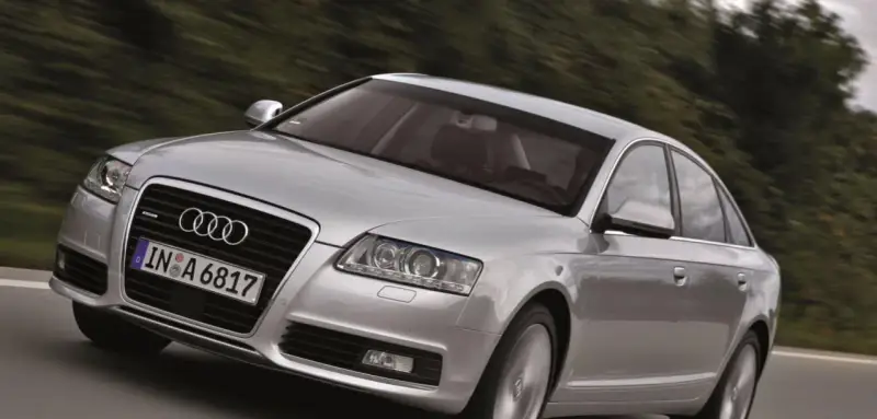 Silberner Audi A6 Limousine 2005 fährt auf einer Landstraße.